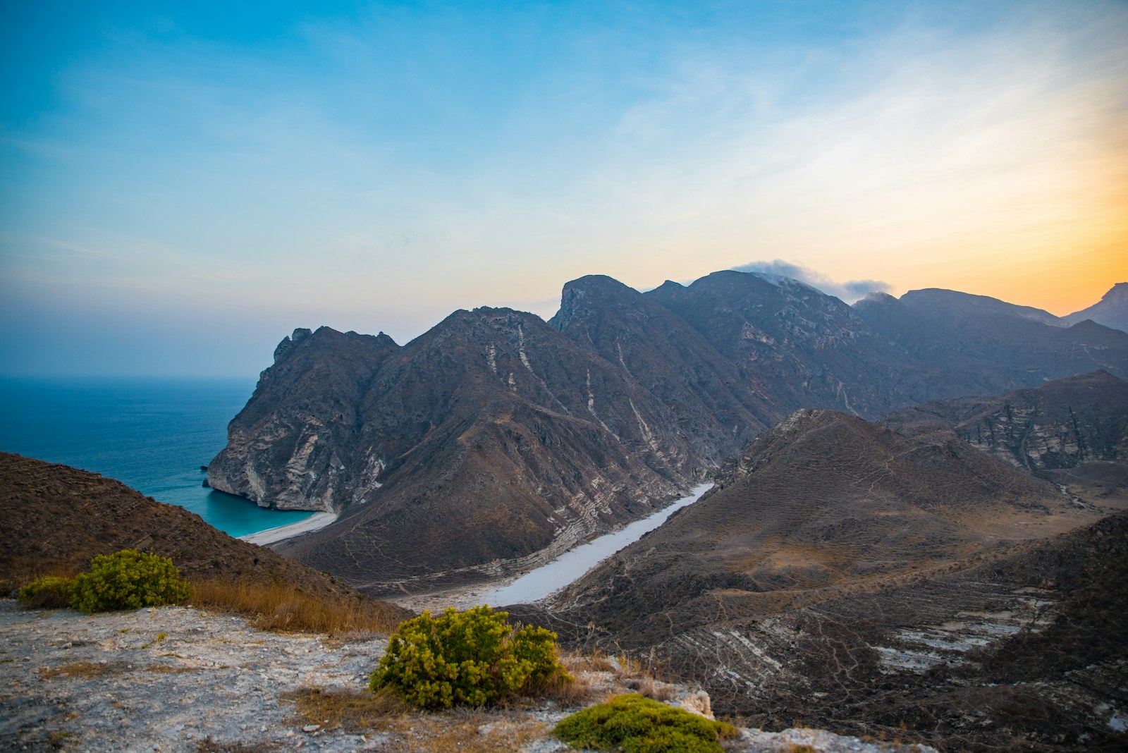 a view of a mountain range with a lake in the distance