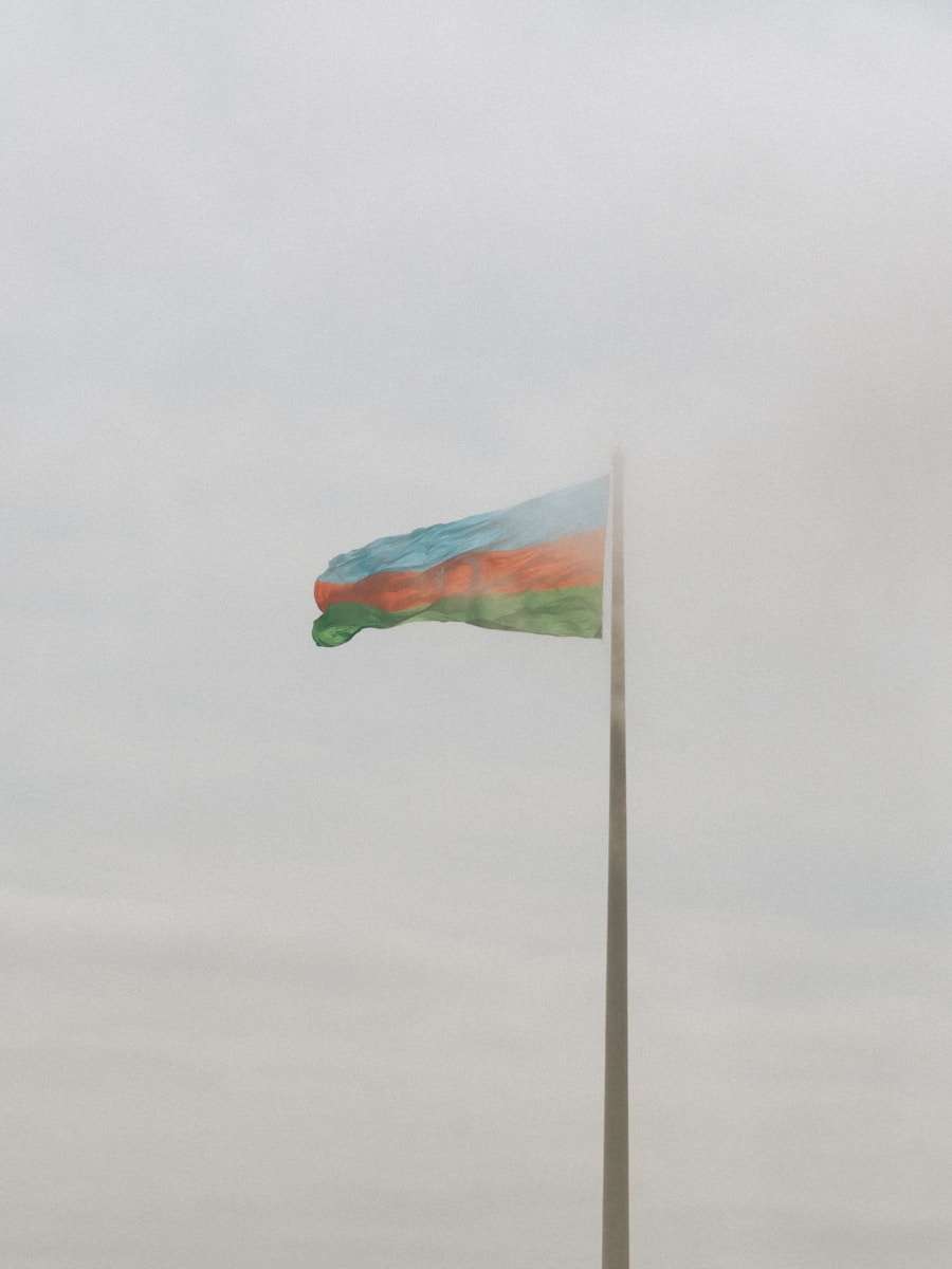 The azerbaijani flag waves in the misty air.