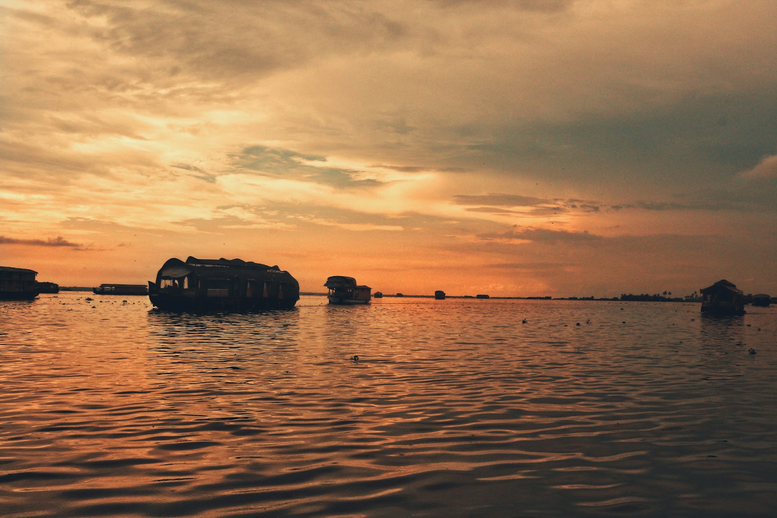silhouette of boat on sea during sunset